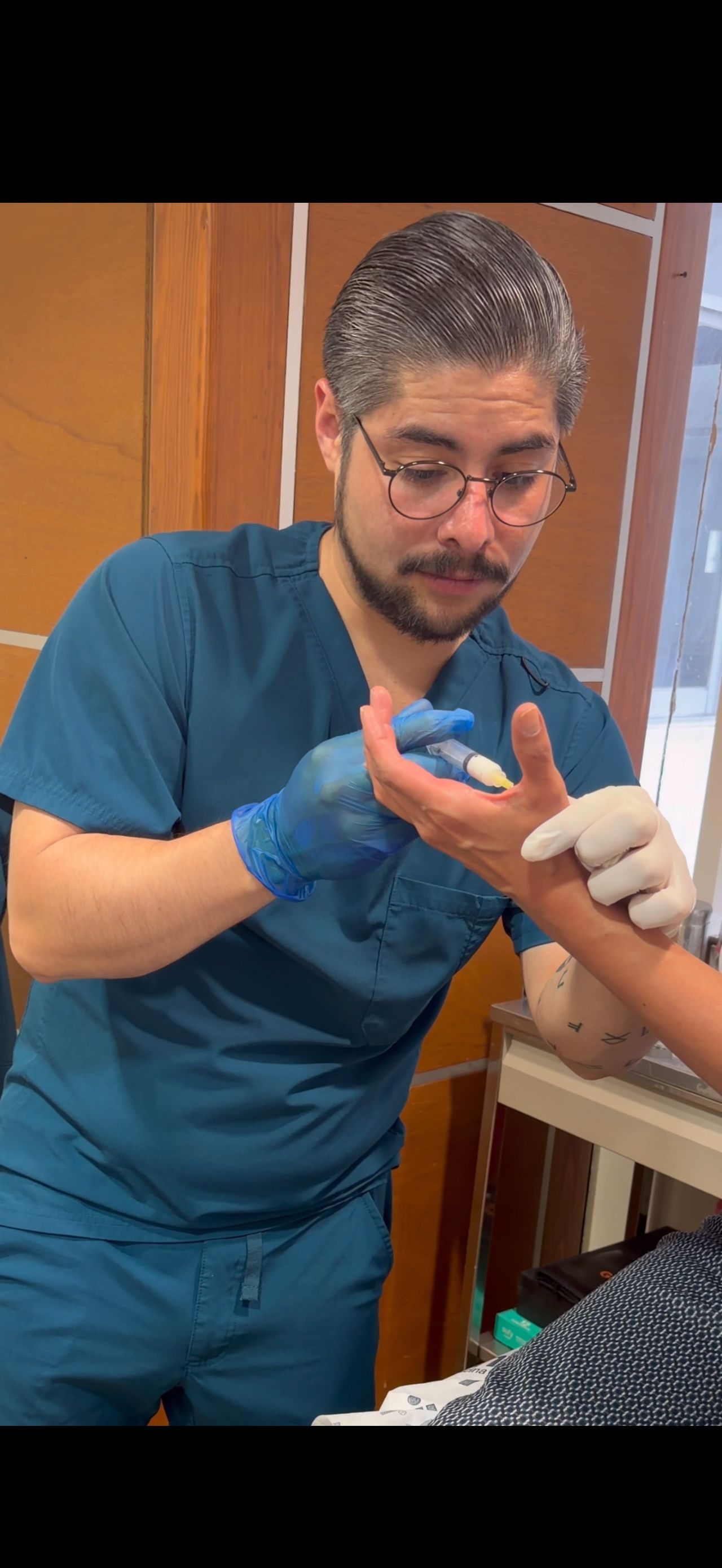 Dr. Hinojosa durante una atención clínica de mano